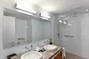 A modern bathroom with a double vanity and a walk-in shower. Voir les images du produit
