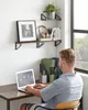 A person working at a desk with shelves of books and decor above. Náhled obrázku produktu