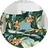 A bed with green floral patterned bedding and a teal pillow. Produktbild-Vorschau