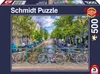 The image shows the front of a Schmidt Puzzle box featuring a canal scene in Amsterdam with bicycles in the foreground. Produktbild-Vorschau