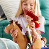 A young girl is playing with a Toy Story action figure of Jessie riding on Bullseye. Podgląd zdjęcia produktu
