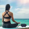 A woman meditating by the sea with a steel tongue drum and mallets. Produktbild-Vorschau
