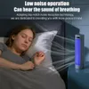 A woman sleeping in bed next to a small tower fan emitting blue light and airflow. Anteprima dell’immagine prodotto