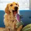 A golden retriever dog with its mouth wide open is about to bite a plush fish toy. Produktbild-Vorschau