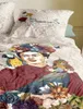 A close-up view of a bedding set featuring a portrait of Frida Kahlo with a parrot and monkey, surrounded by flowers. Produktbild-Vorschau