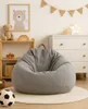 A child's room with a bean bag chair, a dresser, and toys. Produktbild-Vorschau