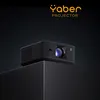 A black Yaber projector is displayed on a black pedestal against a dark background. Anteprima dell’immagine prodotto