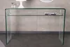 A clear glass console table with a shelf, placed against a textured gray wall. Produktbild-Vorschau