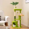 A green cat tree with two cats, placed in a living room setting next to a white sofa and a small wooden table. Náhled obrázku produktu