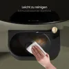 A hand is cleaning a black sink with a white cloth. The sink has a gold faucet. Text is overlaid on the top part of the image. Anteprima dell’immagine prodotto