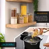 Kitchen scene with glass storage jars on a shelf and pasta being cooked in a pot. Náhled obrázku produktu