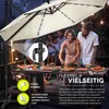 People enjoying a meal outdoors under a large umbrella. Náhľad obrázku produktu