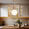A modern kitchen scene featuring a pendant light. Voir les images du produit