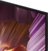 A close-up view of the corner of a television screen displaying a colorful abstract image. Voir les images du produit