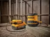 DeWalt battery and speaker on a wooden surface with a wooden wall in the background. Podgląd zdjęcia produktu