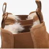 A close-up view of the top opening of two brown UGG boots, showing the fluffy white lining. Voir les images du produit