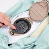 A hand is pressing a switch on a device that is part of a mint green fabric item. Anteprima dell’immagine prodotto