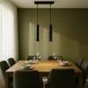 A dining table set with plates and glasses, illuminated by two pendant lights. Náhled obrázku produktu