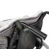 A close-up view of a wheelchair accessory, likely a footmuff or liner, attached to the handle of a wheelchair. Produktbild-Vorschau