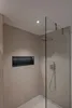 A modern bathroom shower with a glass enclosure and a built-in niche. Anteprima dell’immagine prodotto