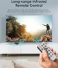 A hand holding a remote control in front of a TV displaying a scenic landscape. Produktbild-Vorschau