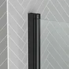 A close-up view of a black shower screen frame against a gray tiled wall. Podgląd zdjęcia produktu