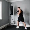 A man is boxing in a room with a punching bag. Produktbild-Vorschau