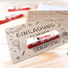 Birthday invitations with Kinder chocolate bars on a wooden surface. Produktbild-Vorschau
