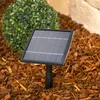 A solar panel kit is shown in a garden setting, surrounded by mulch and a decorative bush. Produktbild-Vorschau