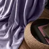 A purple blanket is draped over a basket of books. Anteprima dell’immagine prodotto
