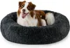 A dog is lying in a round, plush dog bed. Anteprima dell’immagine prodotto