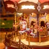 A close-up view of a wooden carousel model with illuminated lights. Produktbild-Vorschau