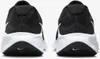 The rear view of a pair of black and white Nike running shoes against a white background. Voir les images du produit