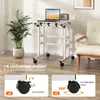 A mobile standing desk with a laptop and a radio on it, placed next to a chair and a plant. Podgląd zdjęcia produktu