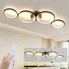 A hand holding a remote control in front of a ceiling lamp with multiple rings, with inset images showing different lighting effects. Produktbild-Vorschau