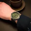 A person's wrist wearing a watch, with a coffee cup in the background. Produktbild-Vorschau