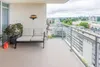 A balcony with a sofa, plant, and a view of a city. Anteprima dell’immagine prodotto