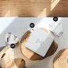 A white wireless charging pad is shown on a wooden surface, with different plug adapters for UK, US, and EU regions. Podgląd zdjęcia produktu