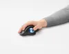 A hand using a black trackball mouse with a blue ball on a white surface. Anteprima dell’immagine prodotto