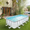 A rectangular above-ground pool is set up on a grassy lawn in a backyard, with a house and other landscaping in the background. Anteprima dell’immagine prodotto
