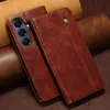 A brown leather phone case is shown with a phone inside. The background is made of rolled leather. Produktbild-Vorschau