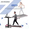A man is walking on a pink treadmill in front of a desk with a monitor, while a woman is running on a similar treadmill in the background. Náhľad obrázku produktu