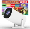 A white projector is shown in front of a screen displaying various streaming service logos and animated characters. Produktbild-Vorschau