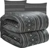 A folded blanket and two pillowcases with a geometric pattern. Anteprima dell’immagine prodotto