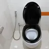 A toilet with a black seat and lid in a bathroom. Produktbild-Vorschau