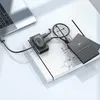 A laptop connected to a USB hub, which is in turn connected to two external hard drives, all placed on a notebook with architectural drawings. Produktbild-Vorschau