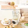 A hand pouring soybeans into a soy milk maker, with a cup of soy milk and some pastries on a table. Voir les images du produit