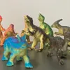 A collection of toy dinosaurs arranged on a dark surface against a light gray and white background. Náhľad obrázku produktu