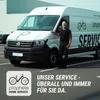 A man stands next to a service van with the company logo and text on it. Produktbild-Vorschau