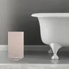 A beige trash can is placed next to a white bathtub in a bathroom. Anteprima dell’immagine prodotto